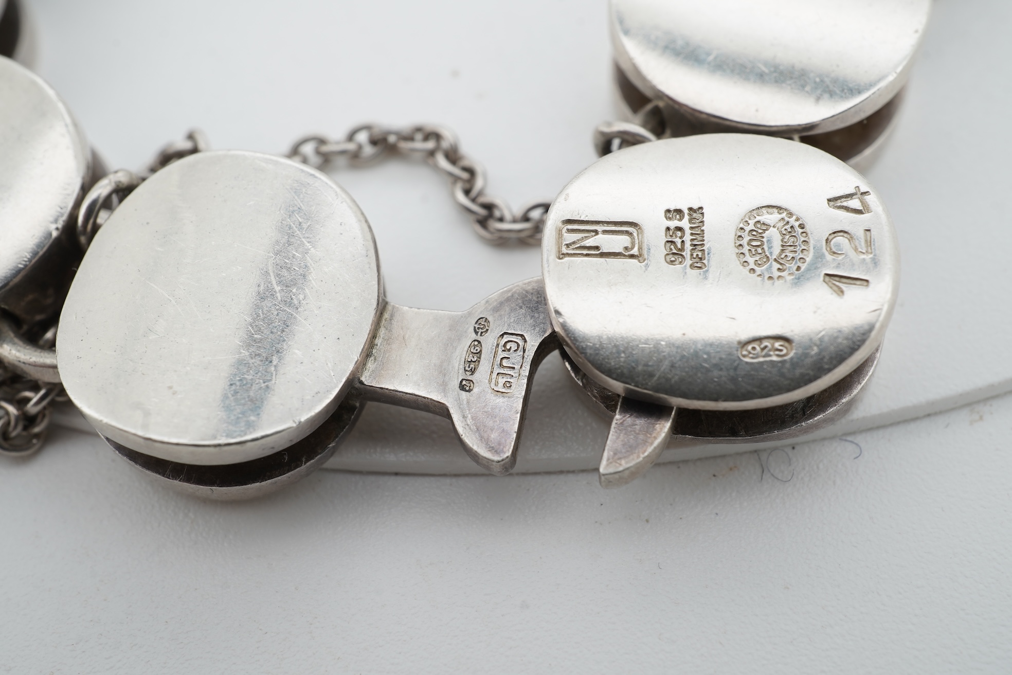 Nanna Ditzel for Georg Jensen, a silver bracelet, circa 1972, and a Georg Jensen ring, circa 1968, the bracelet composed of polished oval links with a concealed hoop clasp, length approximately 17cm, signed Georg Jensen,